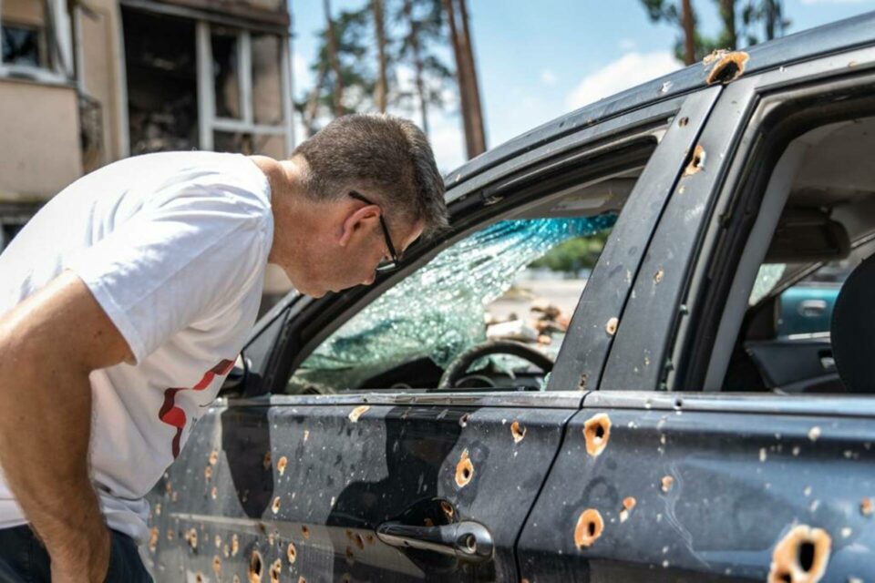 CEO Paul Anticoni looking into gun-shot ridden car window