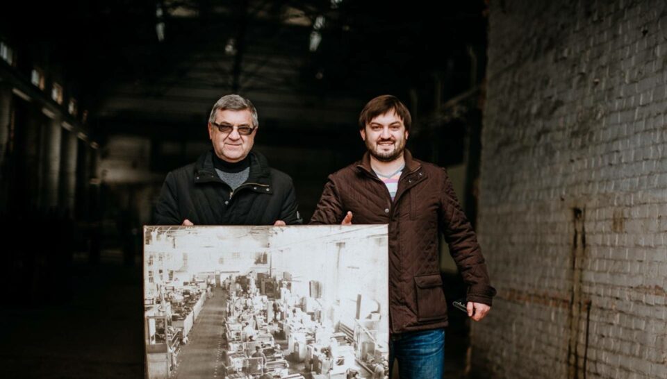 Vardan standing with his father behind a photograph