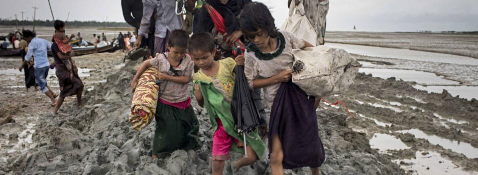 Disaster fund children carrying belongings in the mud