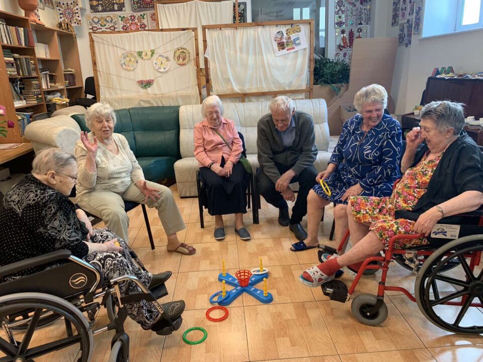 A group of elderly people playing games in a circle