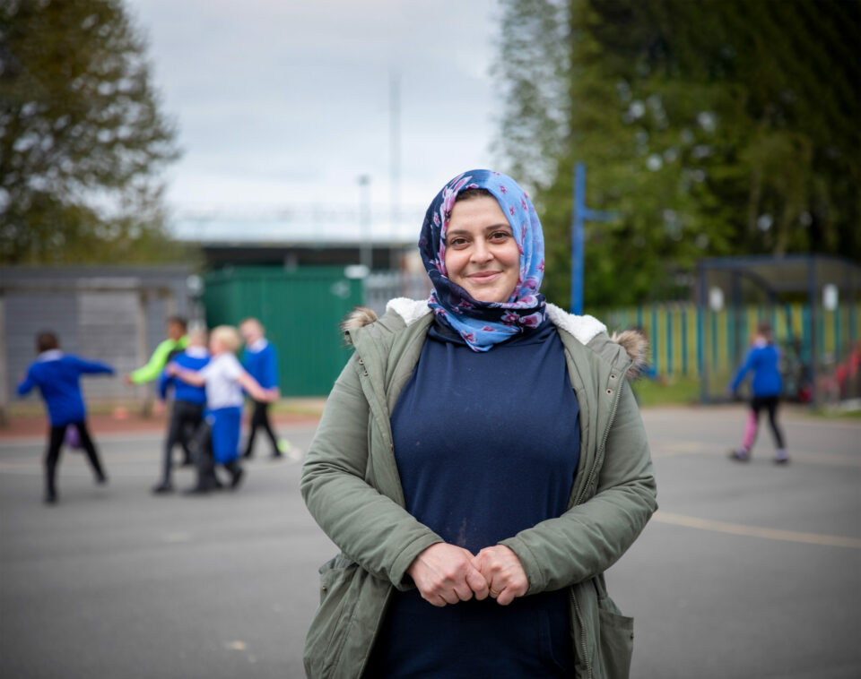 Woman in a playground facing the camera, wearing a hijab