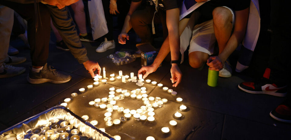memorial candles being laid out in a Star of David at a Vigil for victims